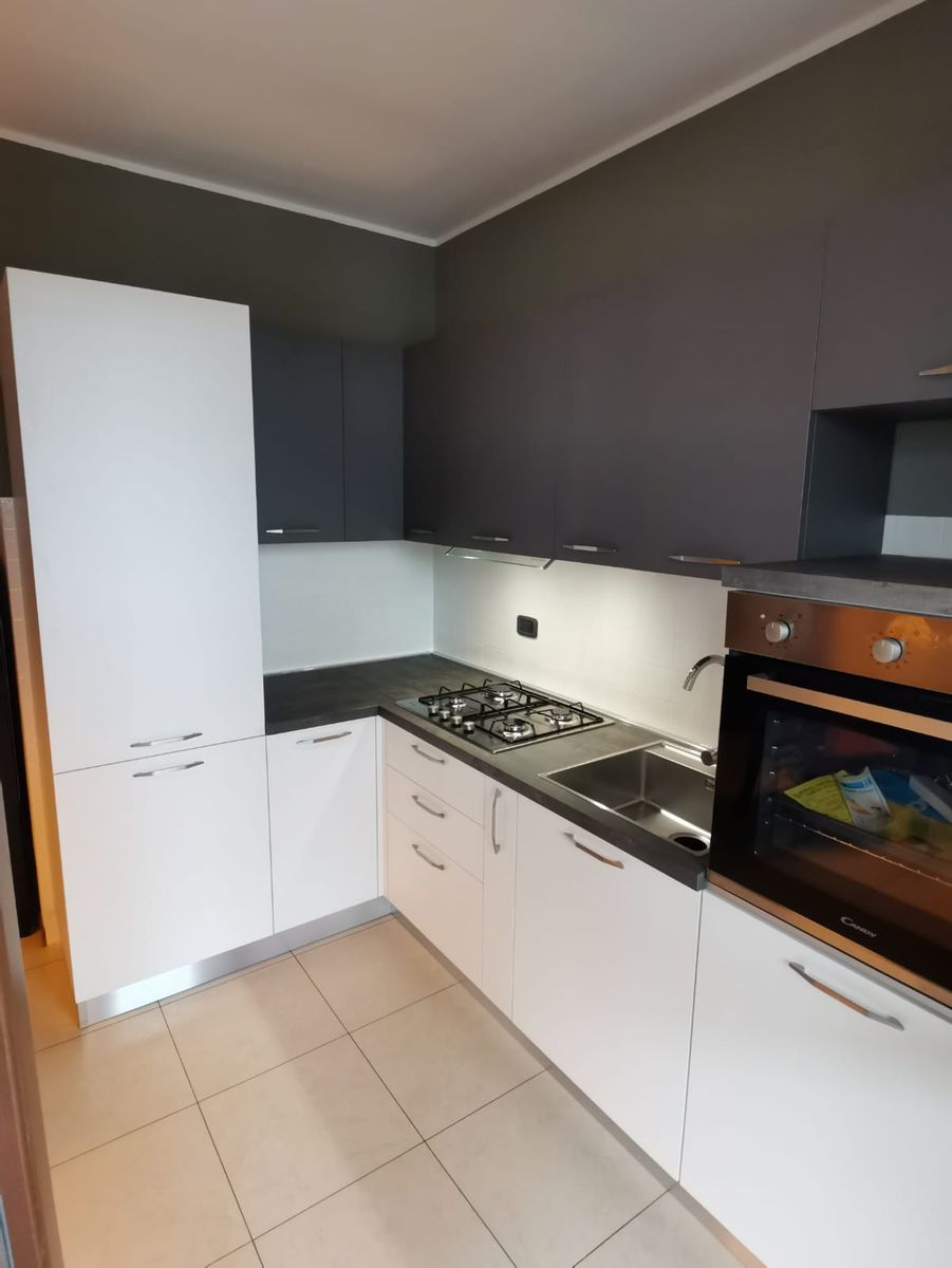 Cucina ad angolo con basi bianche e pensili antracite