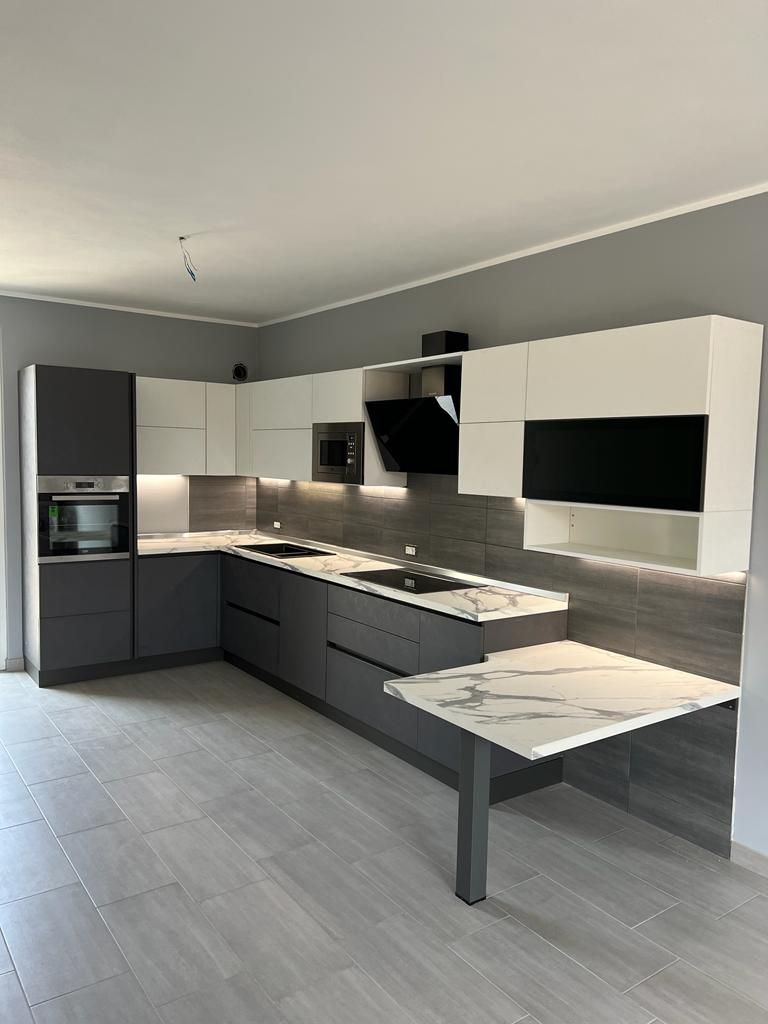 Cucina antracite con colonne, isola e tavolo effetto marmo
