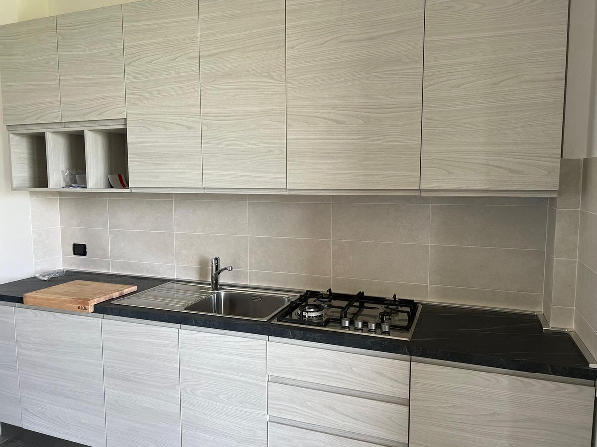 Cucina lineare in essenza chiara con piano nero